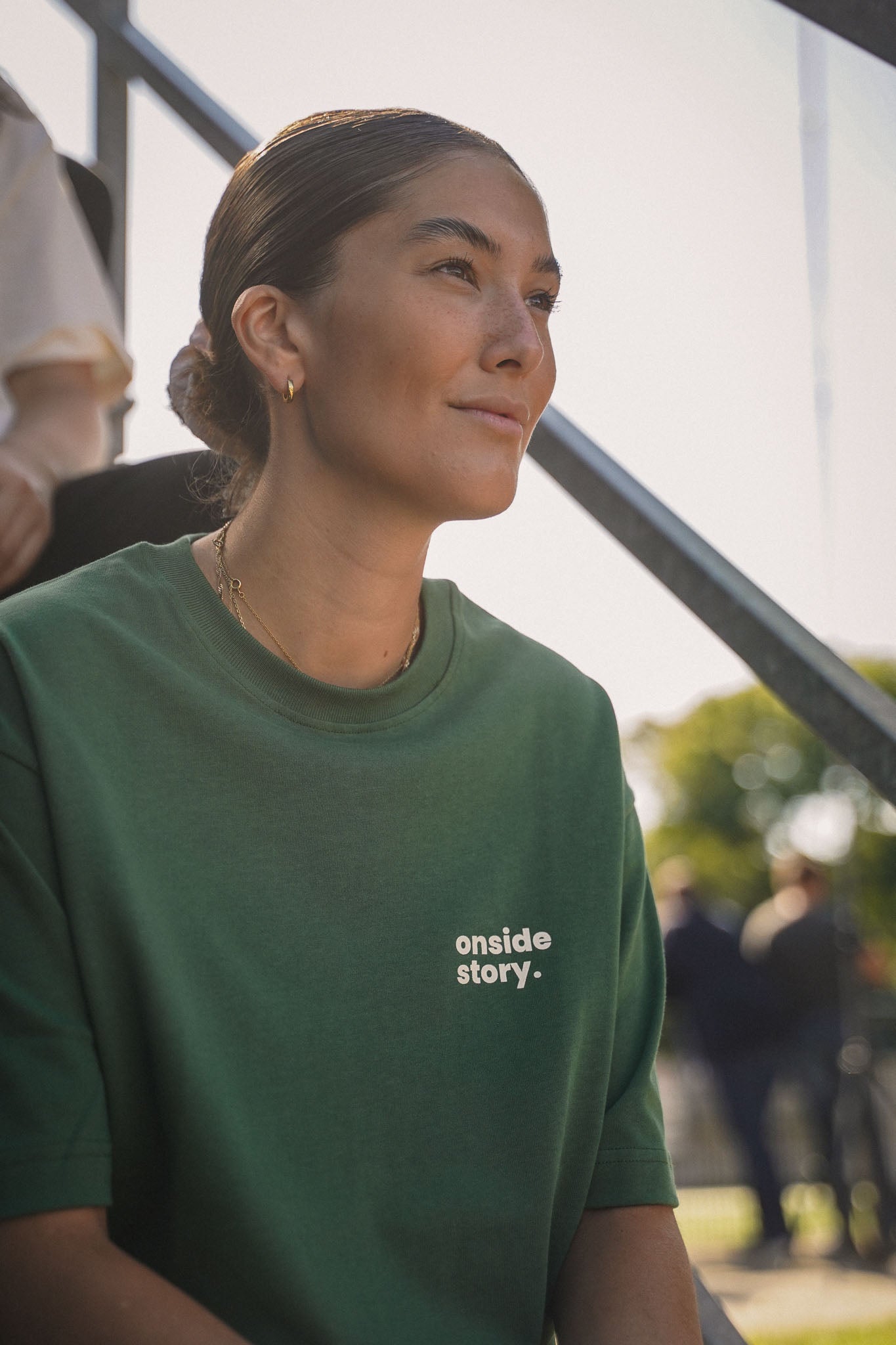 Detailansicht des "sonntach is spieltach" Shirts in Bottlegreen, getragen von einem Model im Portrait-Stil.