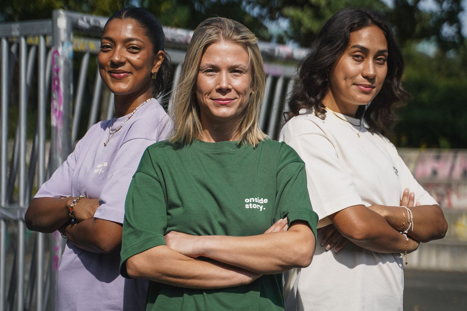 Drei junge Frauen stehen auf einem Bolzplatz und tragen die "sonntach is spieltach"-Shirts in Lavender, Bottlegreen und Cream aus Chapter one.