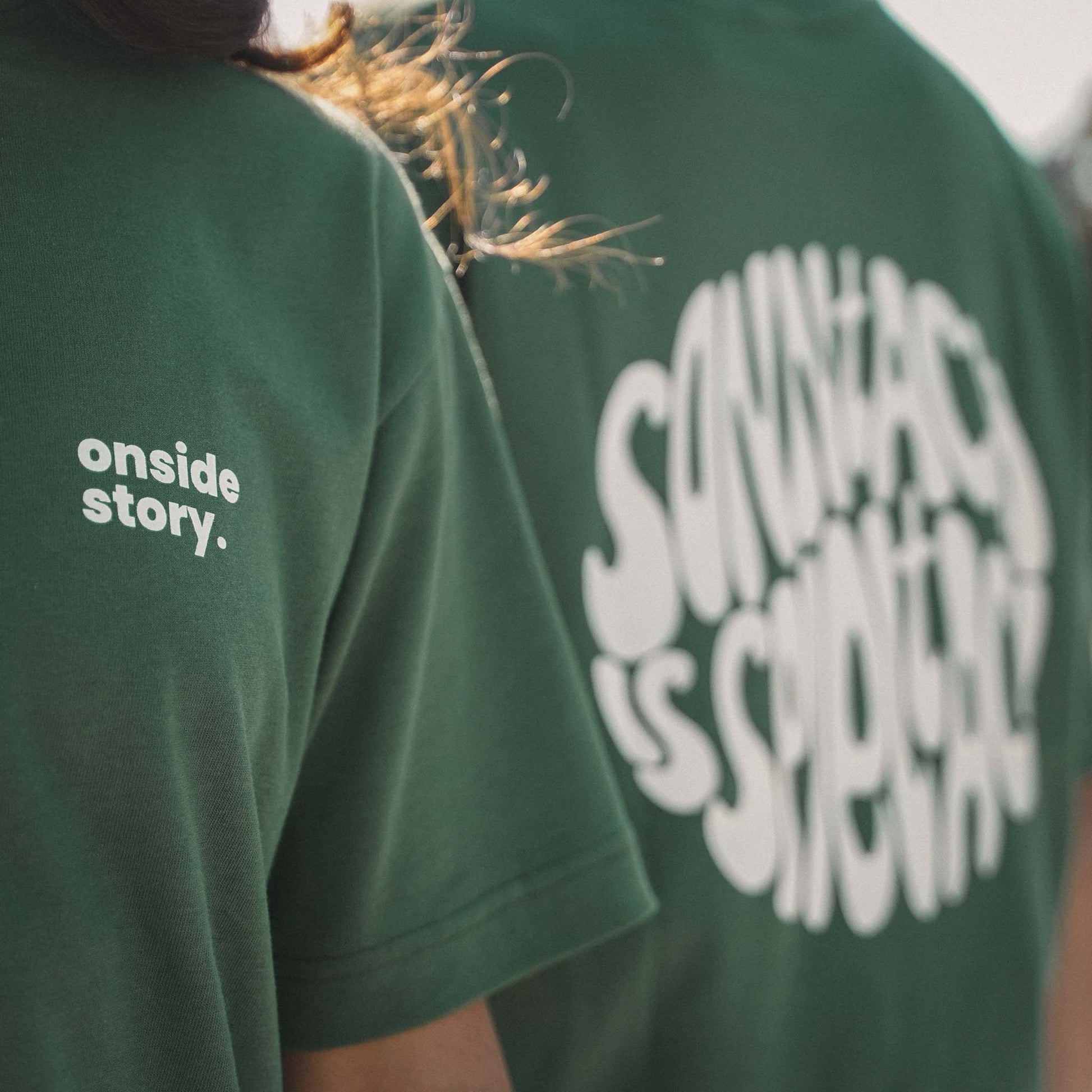 Detailansicht des Front- und Backprints des "sonntach is spieltach"-Shirts in Bottlegreen.